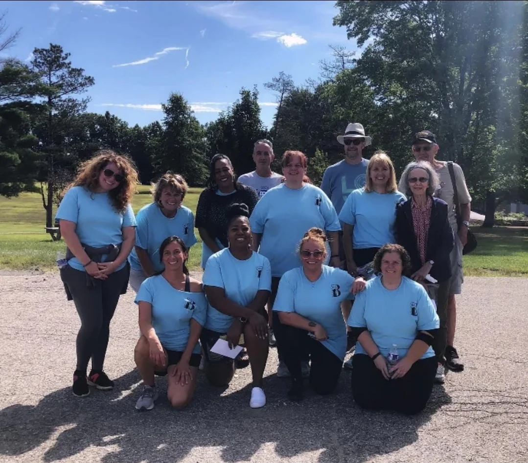 Back To The Garden Cleaning team and volunteers in matching blue shirts outdoors